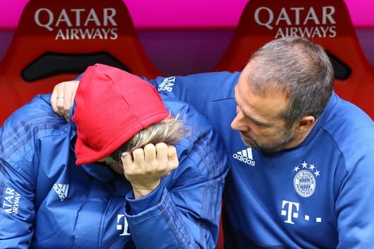 Javi Martinez (l) sitzt auf der Bank und wird von Co-Trainer Hansi Flick getröstet.