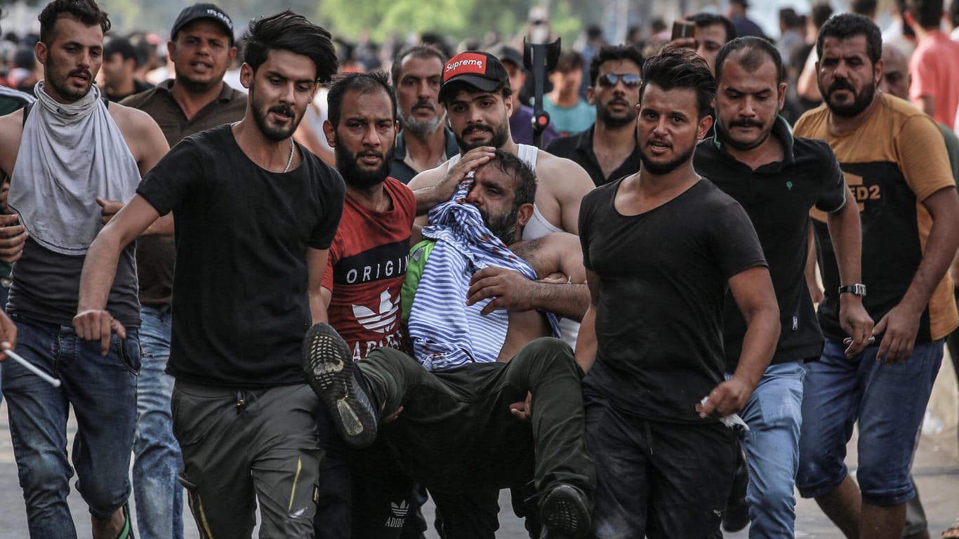 Demonstranten mit Verletztem im Irak: Die UN fordert ein Ende der Gewalt.