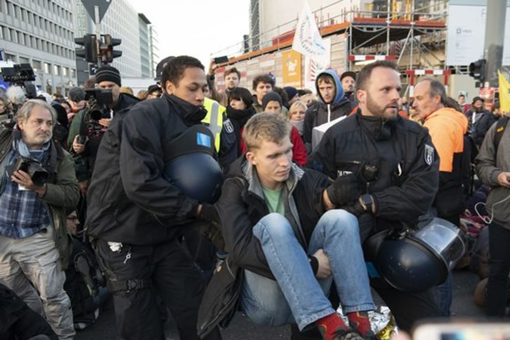 Polizisten tragen einen Aktivisten der Klimabewegung Extinction Rebellion am Potsdamer Platz weg.
