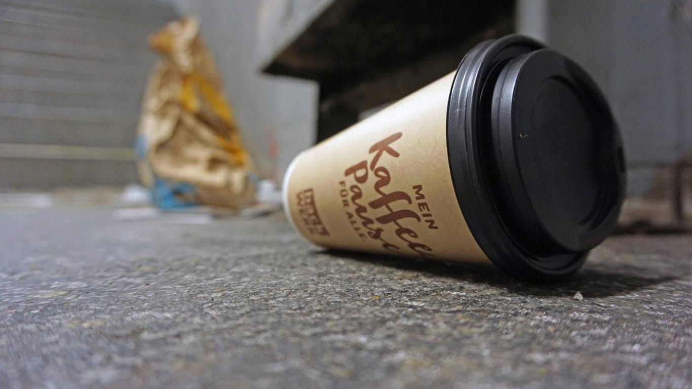 Ein leerer Pappbecher liegt achtlos weggeworfen auf dem Boden: Falsche Müllentsorgung kann teuer werden.