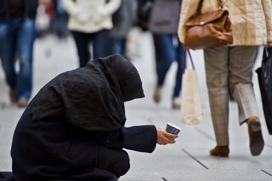 Eine Frau bittet auf der Einkaufsmeile Zeil um Almosen.