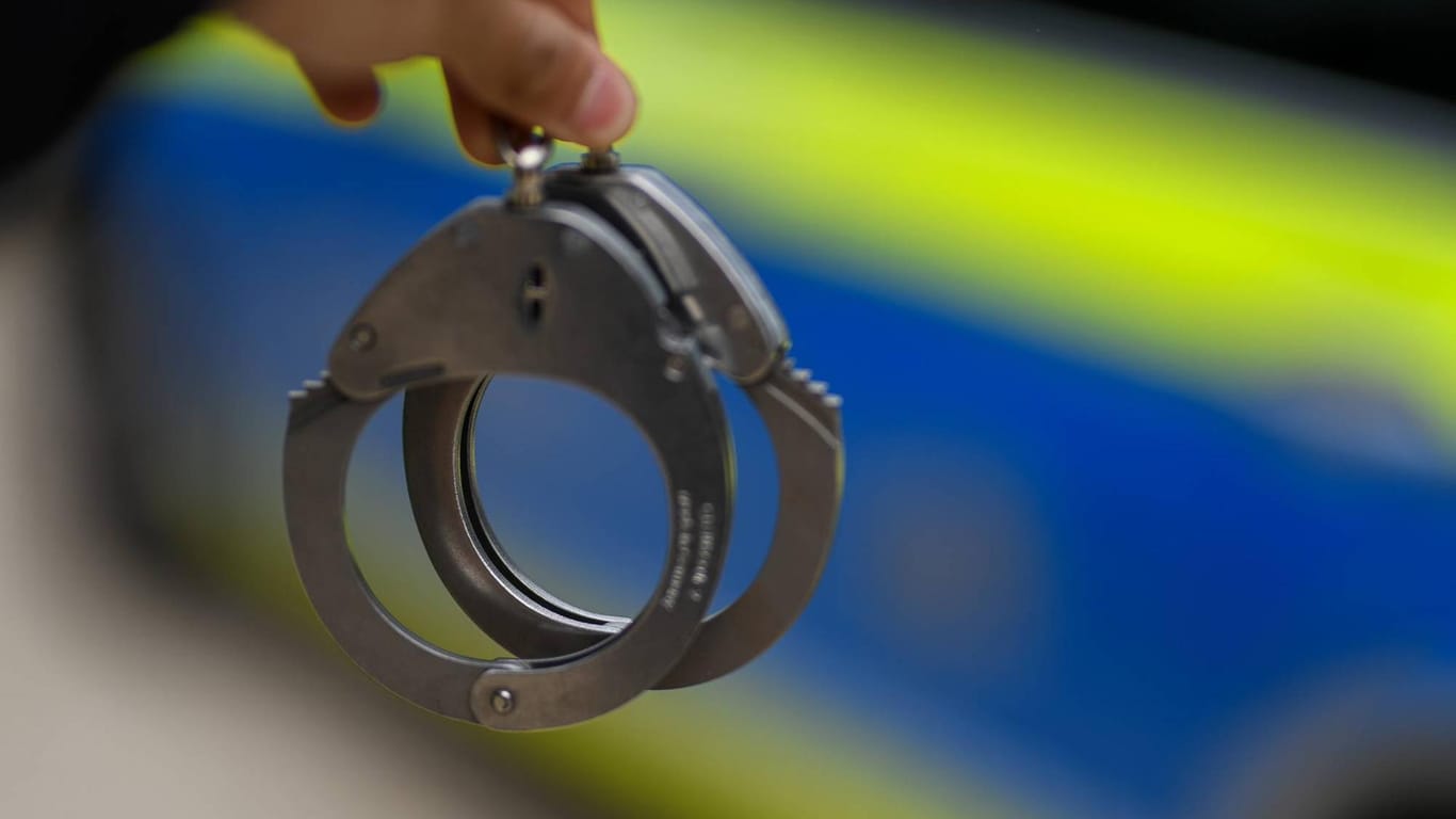 Ein Polizist hält ein Paar Handschellen: Der Gesuchte bleibt bis zur Verhandlung in Untersuchungshaft.