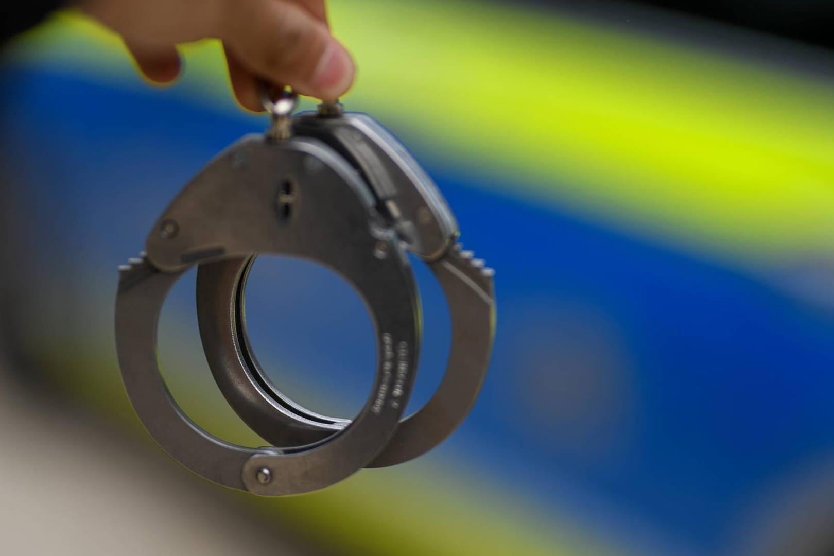 Ein Polizist hält ein Paar Handschellen: Der Gesuchte bleibt bis zur Verhandlung in Untersuchungshaft.