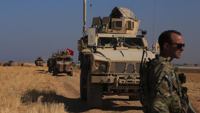 Gemeinsame Mission: Amerikanische und türkische Militärfahrzeuge partrouillieren vergangene Woche in der Sicherheitszone an der syrisch-türkischen Grenze.