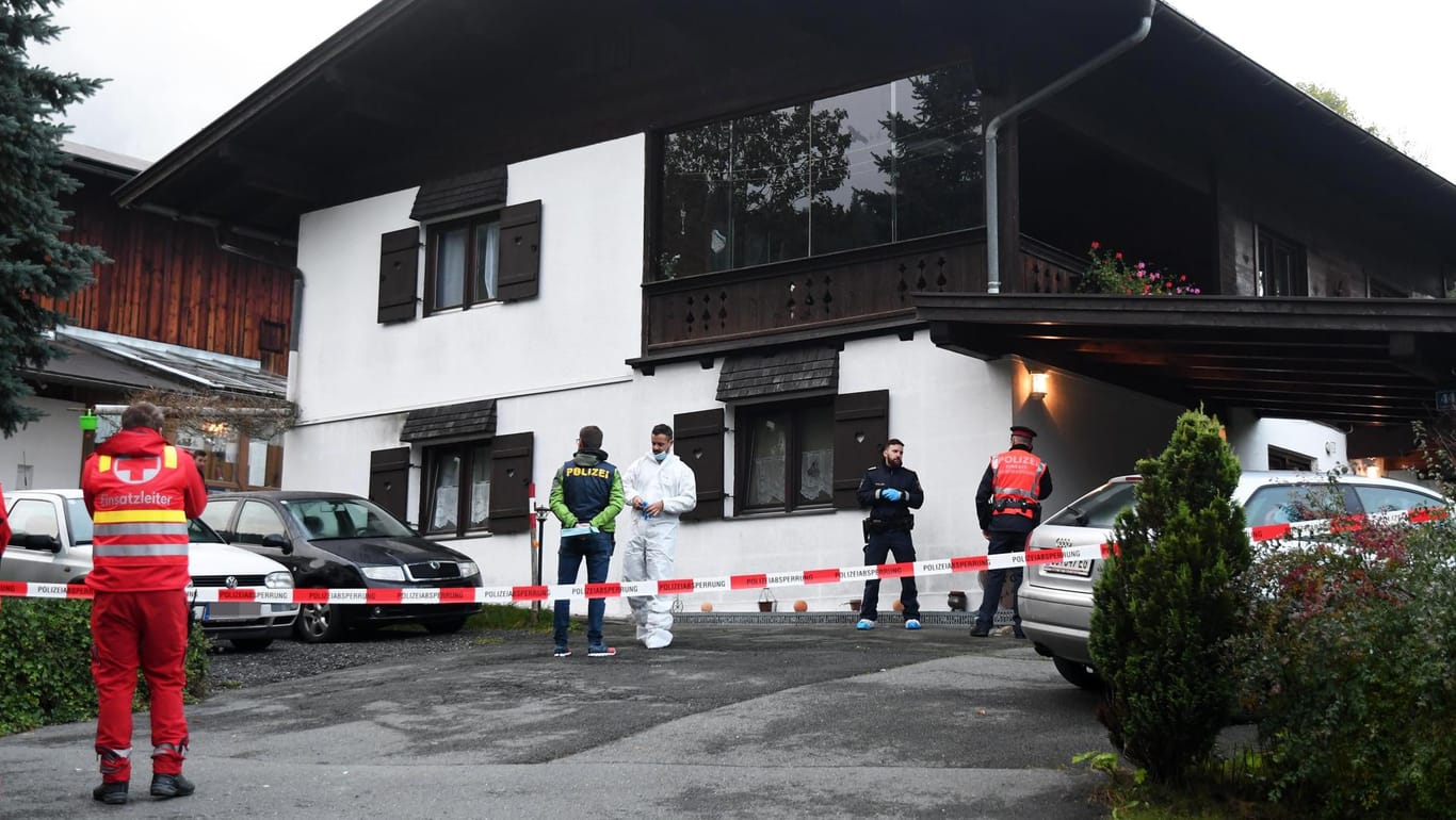 Polizisten und Rettungungskräfte stehen vor dem Einfamilienhaus in Kitzbühel:: Der Ort in den Alpen steht nach der Tat unter Schock.