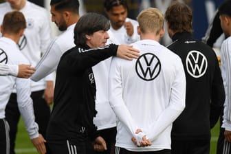 Bundestrainer Joachim Löw klopft Julian Brandt auf die Schulter: Der BVB-Profi könnte eine Chance in der Startelf bekommen.