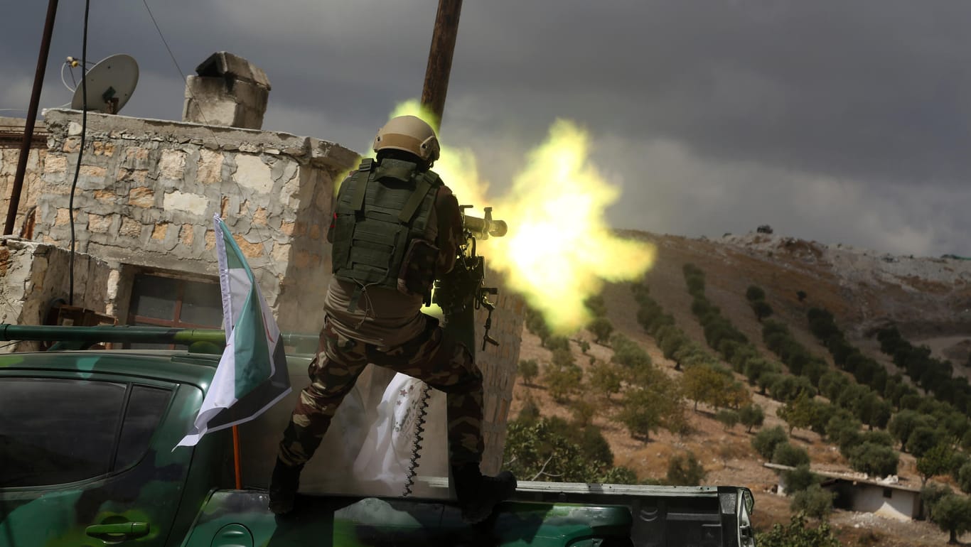 Azaz: Ein Soldat der "Freien syrischen Armee", die von der Türkei unterstützt wird, steht während eines militärischen Trainingsmanövers auf einem militärischen Fahrzeug und feuert ein schweres Maschinengewehr ab.