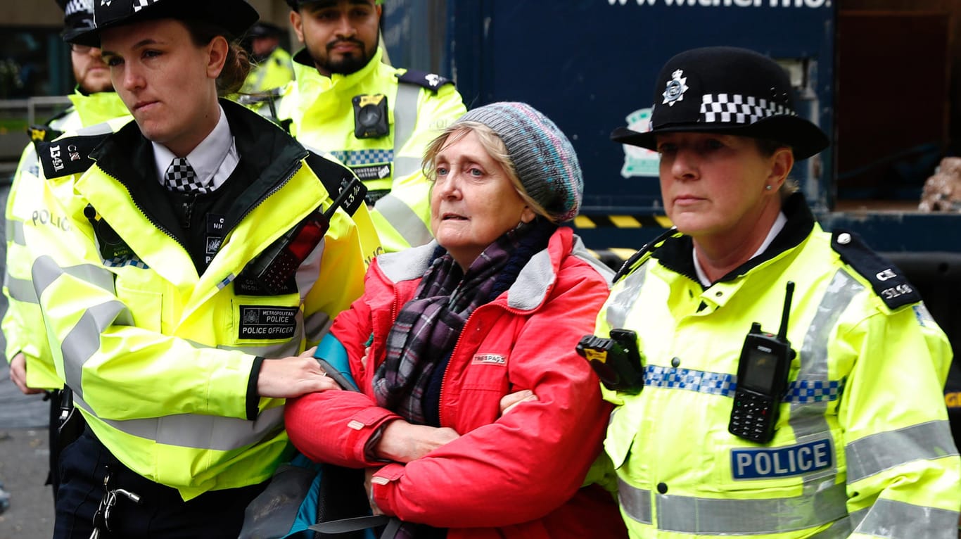 Eine Klimaktivistin wird in London von der Polizei abgeführt.