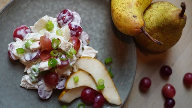 Weintrauben halbiert, Hühnerbrust und Frühlingszwiebeln klein geschnitten - und schon ist der Geflügelsalat fertig.