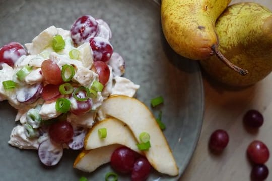 Weintrauben halbiert, Hühnerbrust und Frühlingszwiebeln klein geschnitten - und schon ist der Geflügelsalat fertig.