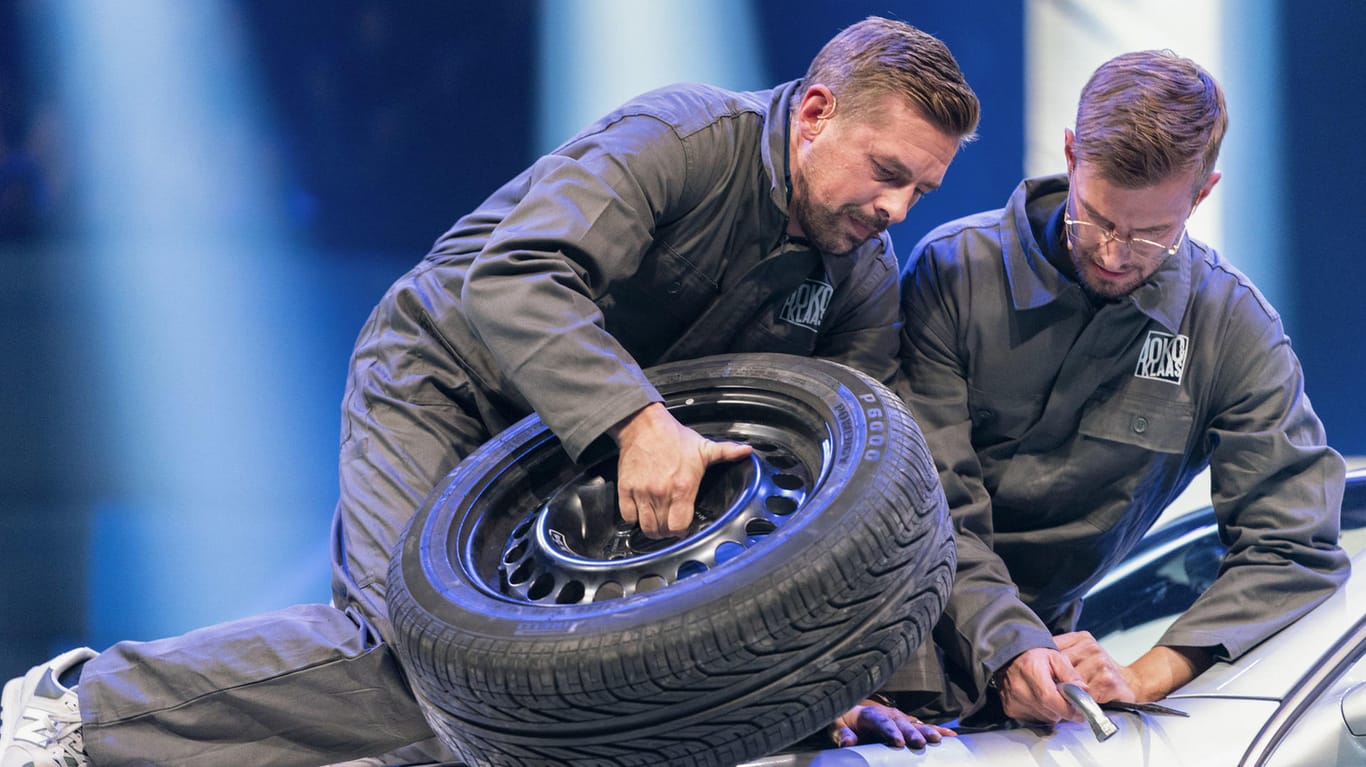 Joko Winterscheidt und Klaas Heufer-Umlauf: In ihrer Show müssen sie auf der Motorhaube eines Autos sitzend einen der Vorderreifen wechseln.
