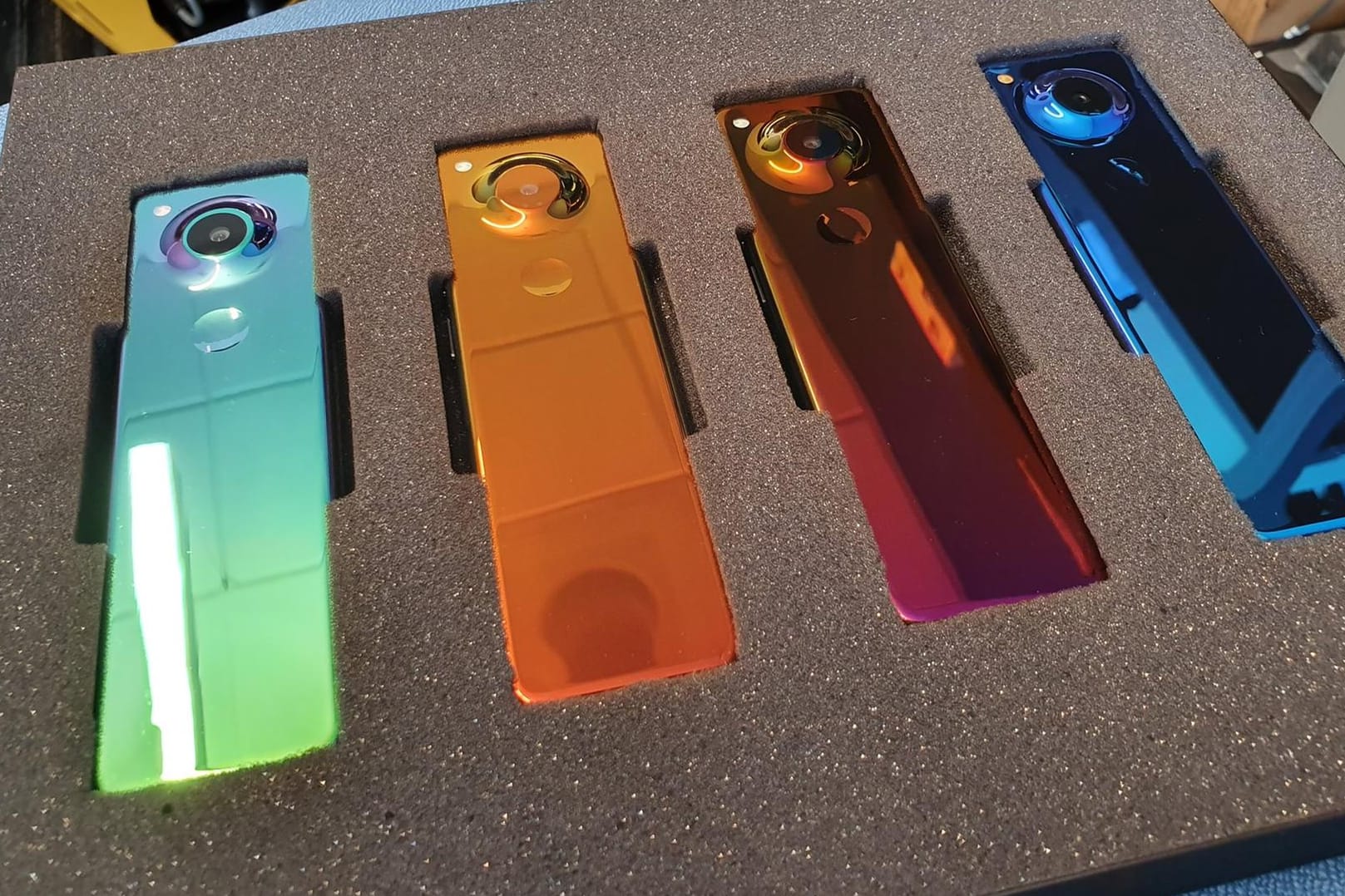 Vier Prototypen des neuen "Essential Gem" Smartphones liegen in einem Schutzkoffer: Die Rückseite schimmert in unterschiedlichen Farben.
