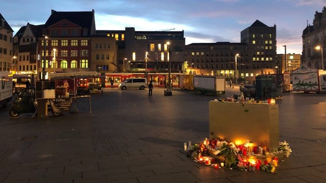 Blumen und Kerzen liegen auf dem Marktplatz in Halle.
