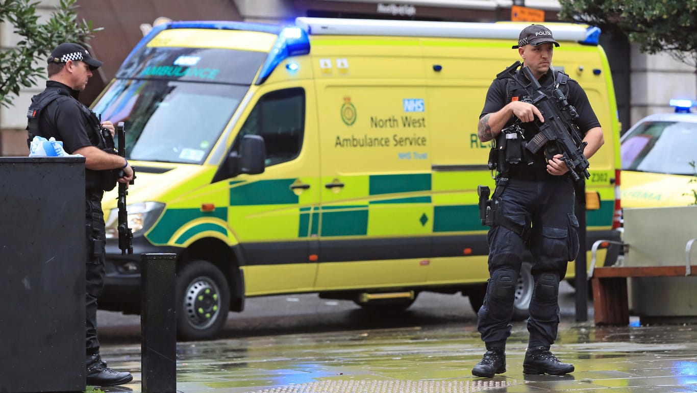 Bluttat in Manchester: Polizisten mit automatischen Waffen kontrollieren nahe eines Einkaufszentrums eine Straße.
