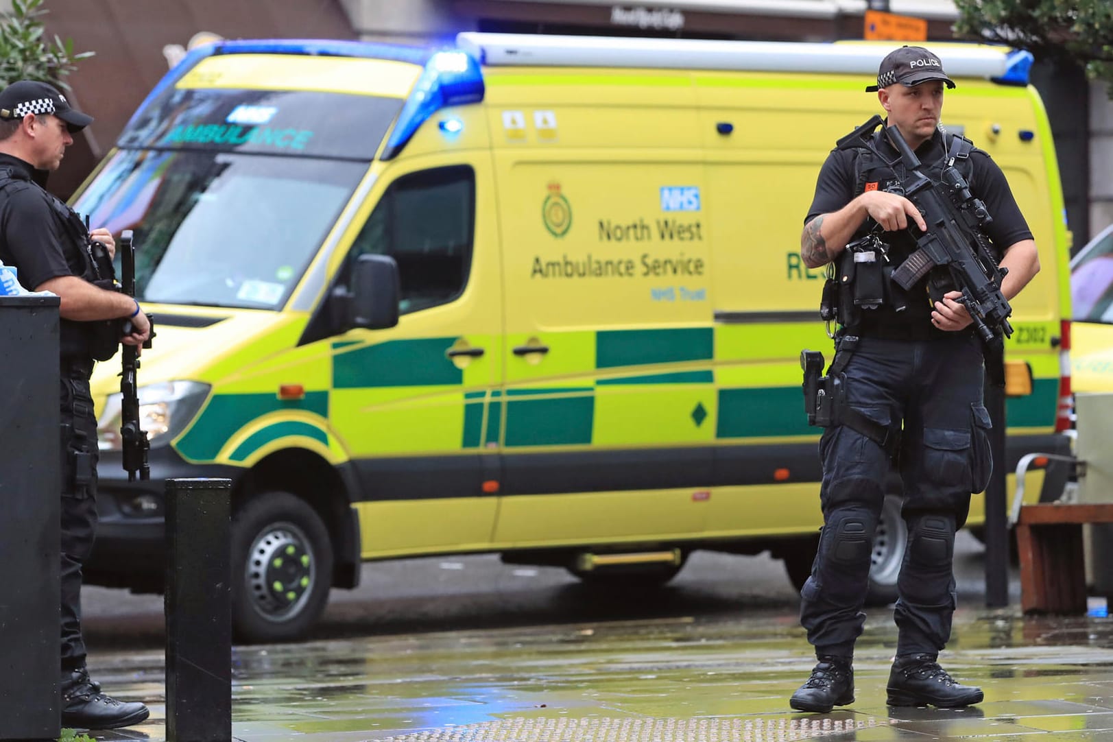 Bluttat in Manchester: Polizisten mit automatischen Waffen kontrollieren nahe eines Einkaufszentrums eine Straße.