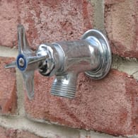 Wasserhahn an einer Häuserwand: Damit das Bewässerungssystem keinen Schaden nimmt, muss es vor dem Frost entsprechend geleert werden.