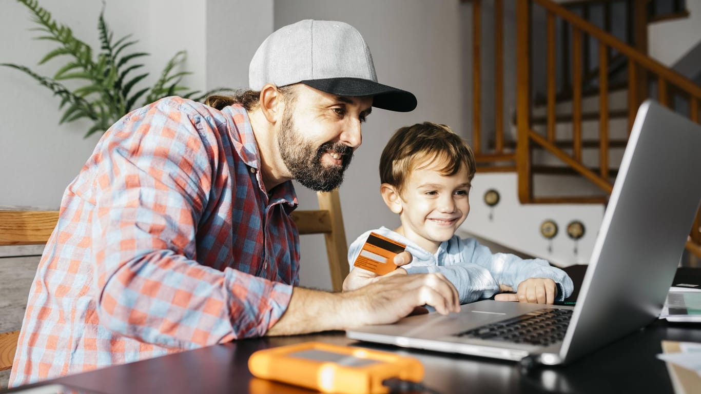 Father and son using laptop together online shopping model released Symbolfoto property released PU