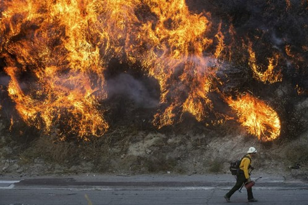 Ein Feuerwehrmann passiert im kalifornischen Newhall eine Wand aus Flammen.