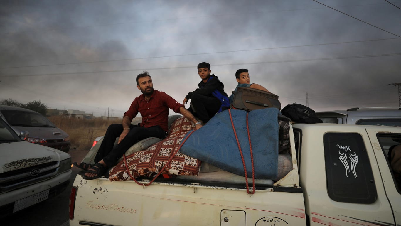 Auf der Flucht: Menschen fliehen auf einem Pickup-Truck aus der Stadt Ras al-Ain an der türkisch-syrischen Grenze.