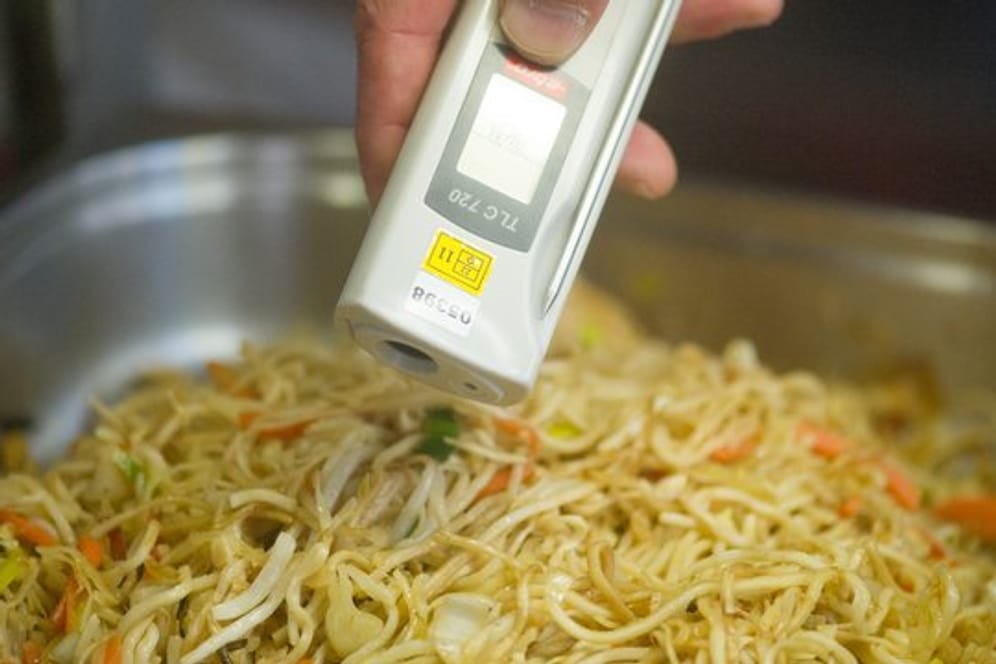 Ein Lebensmittelkontrolleur überprüft bei einer Betriebskontrolle die Temperatur von chinesischen Nudeln.