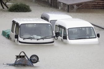 Taifun in Toikio: Fahrzeuge stehen in einem überfluteten Wohngebiet.