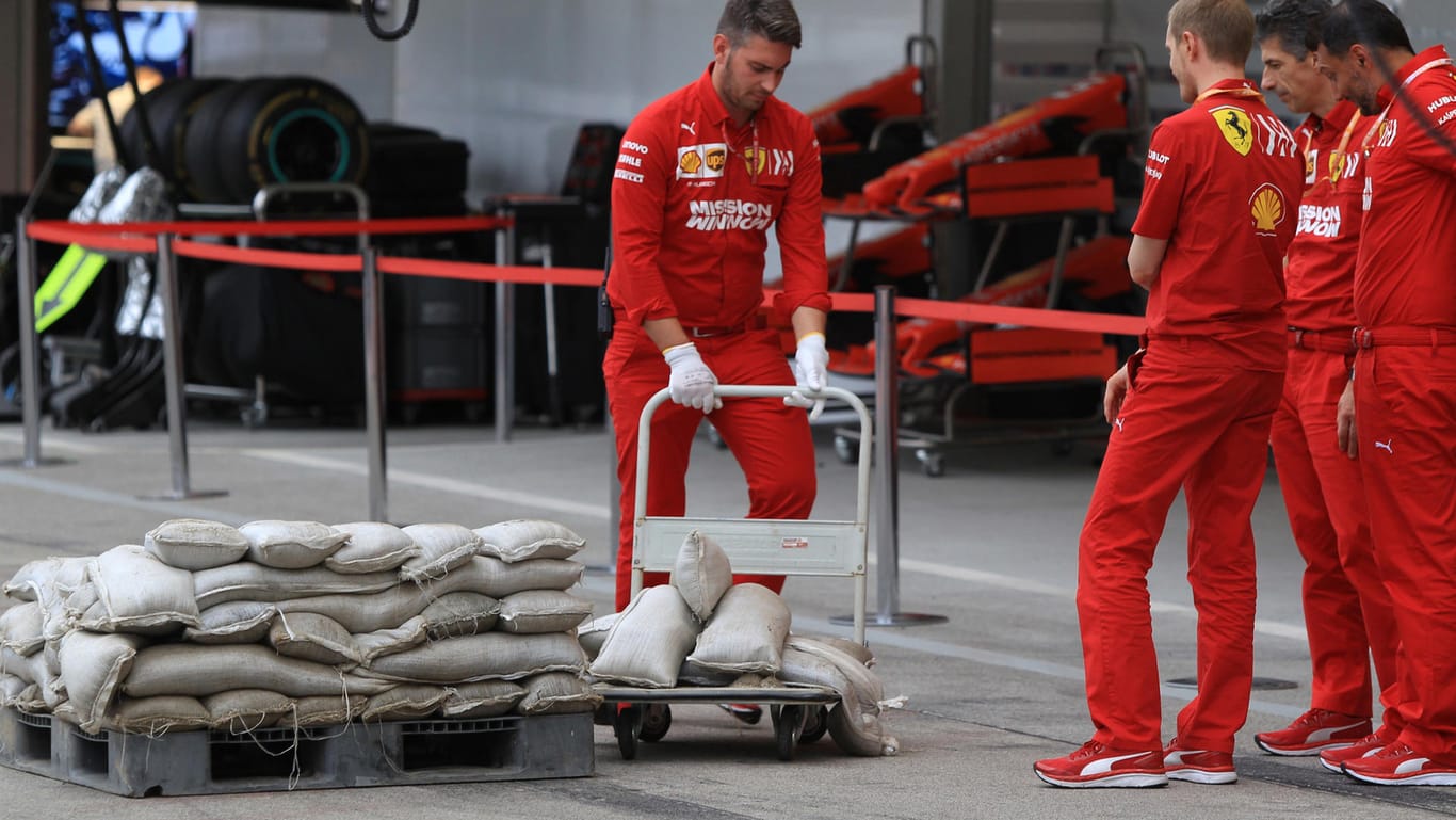 Die Boxencrew von Ferrari schützt ihre Garage mit Sandsäcken vor dem Taifun.