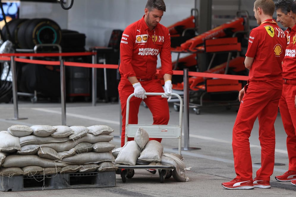 Die Boxencrew von Ferrari schützt ihre Garage mit Sandsäcken vor dem Taifun.