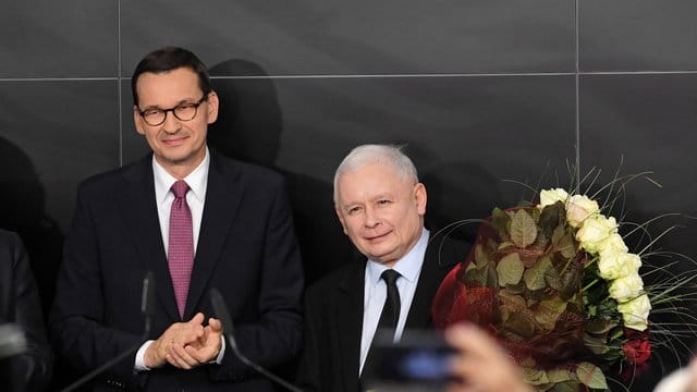 Polens Regierungschef Mateusz Morawiecki (l) und Jaroslaw Kaczynski (r), Vorsitzender der PiS-Partei, am Wahlabend in Warschau. Polens Regierungschef Mateusz Morawiecki (l) und Jaroslaw Kaczynski (r), Vorsitzender der PiS-Partei, am Wahlabend in Warschau.
