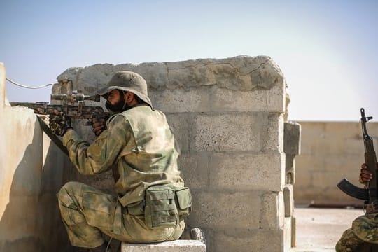 Ein Scharfschütze der mit der Türkei verbündeten Syrischen Nationalarmee zielt mit einer Waffe von einem Dach in Tall Abjad.