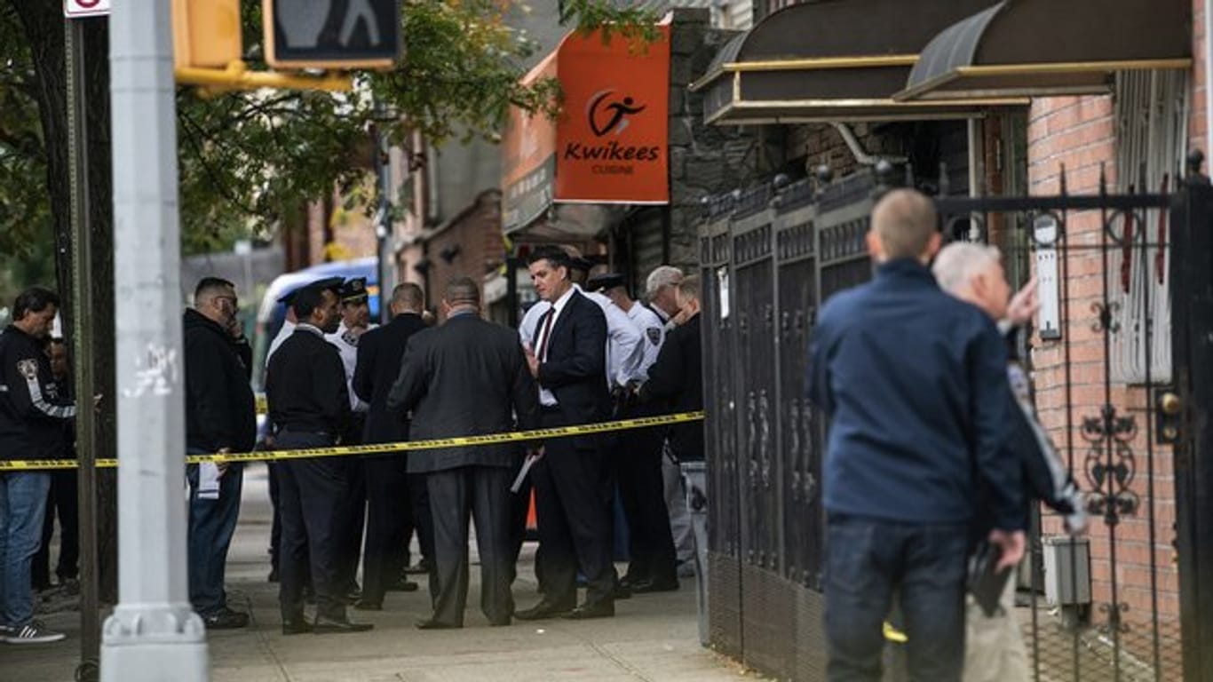 Polizisten stehen vor dem Haus in New York, in dem vier Menschen starben und drei verletzt wurden.