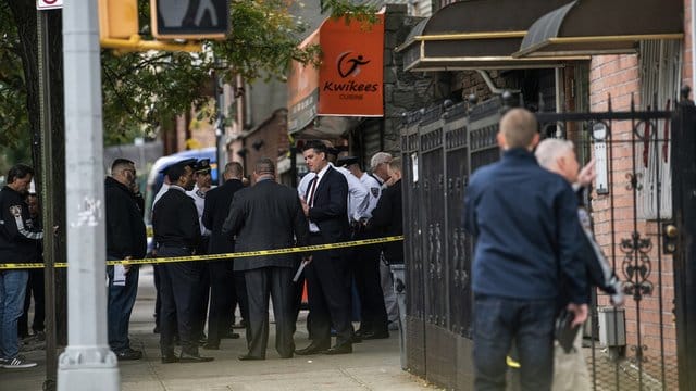 Polizisten stehen vor dem Haus in New York, in dem vier Menschen starben und drei verletzt wurden. Polizisten stehen vor dem Haus in New York, in dem vier Menschen starben und drei verletzt wurden.