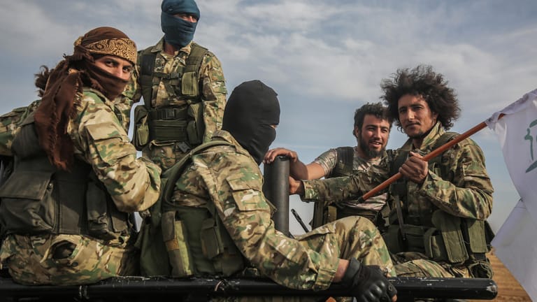 Mitglieder der von der Türkei unterstützten Syrischen Nationalarmee sitzen auf einem Auto: Kurdische Aktivisten werfen Verbündeten der Türkei im Norden Syriens Kriegsverbrechen vor.