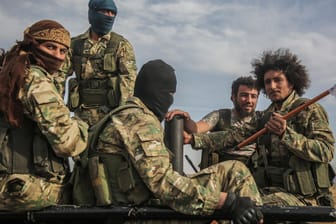 Mitglieder der von der Türkei unterstützten Syrischen Nationalarmee sitzen auf einem Auto: Kurdische Aktivisten werfen Verbündeten der Türkei im Norden Syriens Kriegsverbrechen vor.
