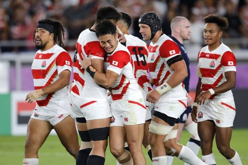 Die Spieler des japanischen Rugby-Teams feiern einen weiteren Versuch gegen Schottland.