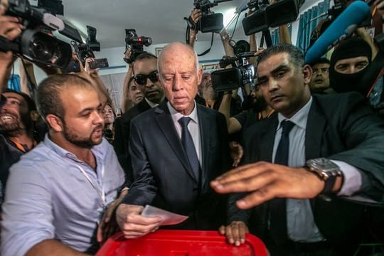 Kais Saied (M), ein ehemaliger Juraprofessor, gibt in einem Wahllokal seine Stimme ab.