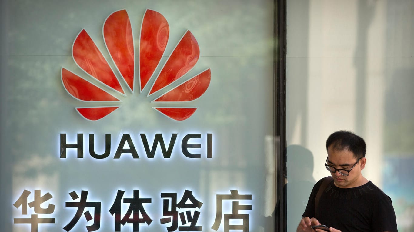 Ein Smartphone-Nutzer steht vor einem Huawei-Shop: Der Konzern aus China liefert wichtige Bauteile für den Ausbau des 5G-Netzes.