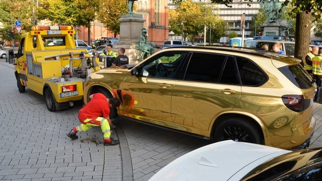 Der goldfarbene SUV wird nahe der Düsseldorfer Königsallee abgeschleppt. Der goldfarbene SUV wird nahe der Düsseldorfer Königsallee abgeschleppt.