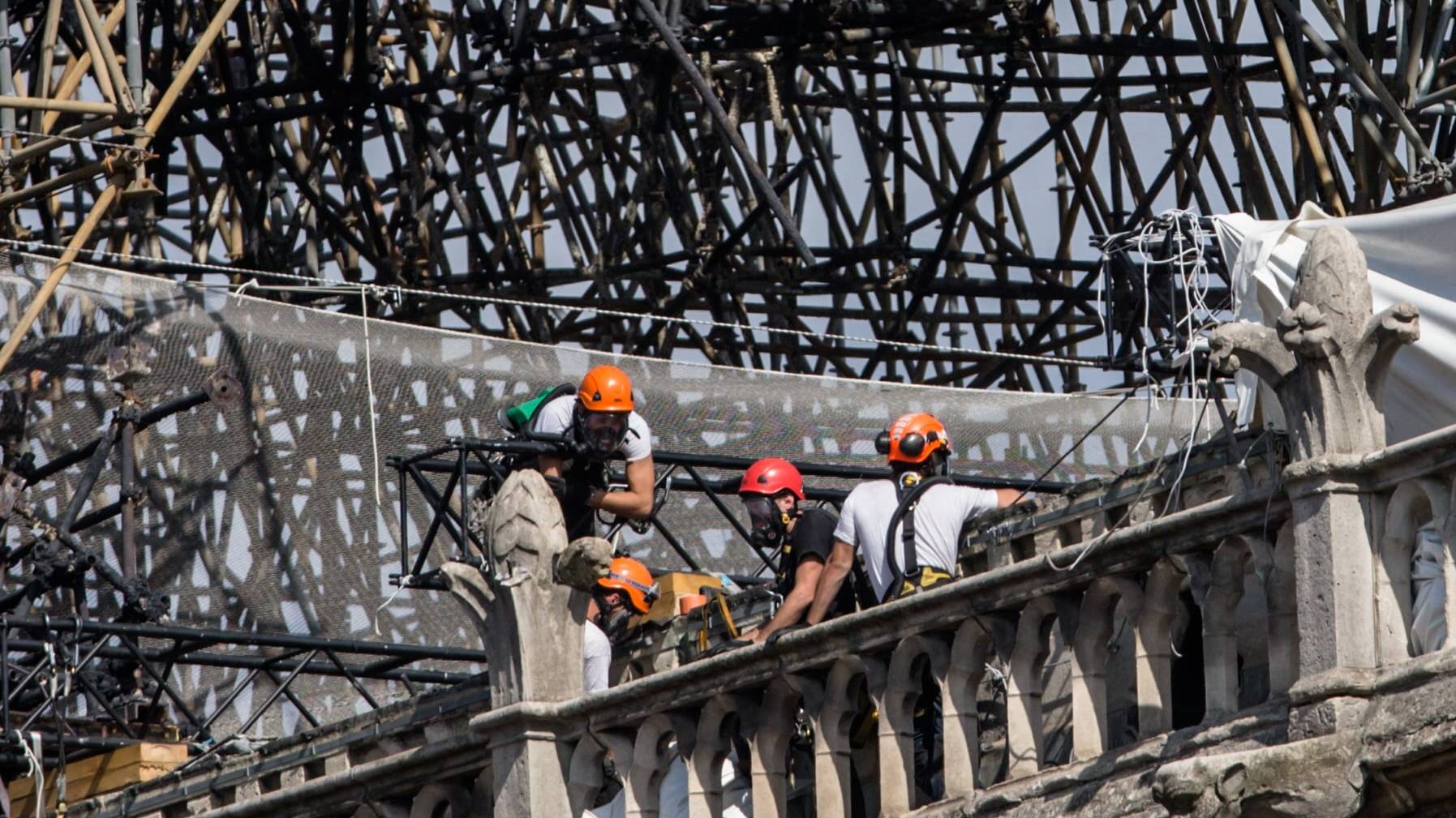 Arbeiter mit Atemmasken bei der Sicherung der Brandstelle: Das freigesetzte Blei aus der Dachkonstruktion macht die Restauration schwierig.