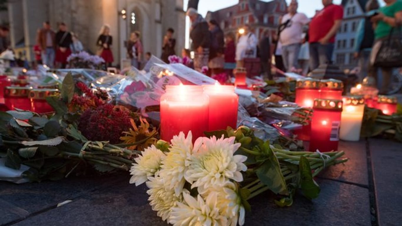Menschen kommen nach einem ökumenischen Gedenkgottesdienst für die Opfer des Terroranschlags in Halle vor der Marktkirche in Halle (Saale) zusammen und stellen Kerzen ab.