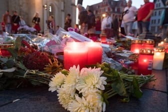 Menschen kommen nach einem ökumenischen Gedenkgottesdienst für die Opfer des Terroranschlags in Halle vor der Marktkirche in Halle (Saale) zusammen und stellen Kerzen ab.