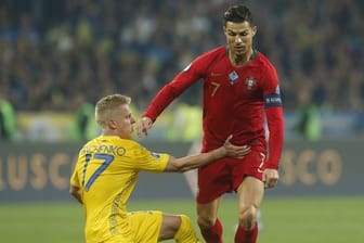 Oleksandr Sintschenko (l) aus der Ukraine und Cristiano Ronaldo aus Portugal kämpfen um den Ball.