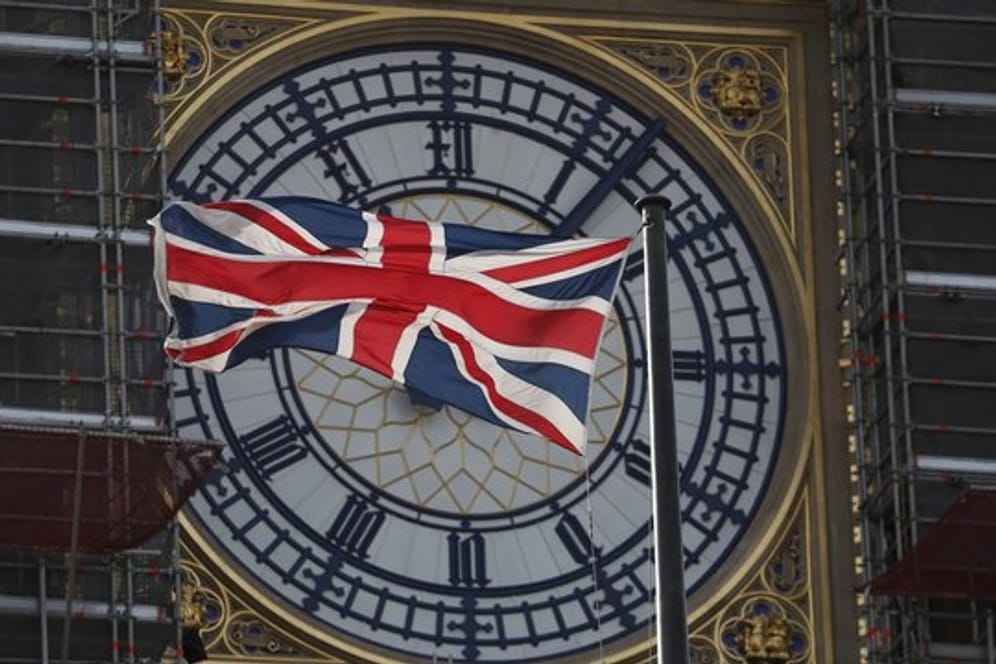 Die Nationalflagge des Vereinigten Königreichs Großbritannien und Nordirland, weht vor dem Zifferblatt des Queen Elizabeth Tower, in dem sich die als "Big Ben" bekannte Glocke befindet, die zu den "Houses of Parliament" gehört.