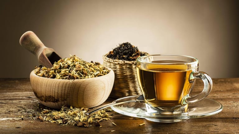 Teetasse und verschiedene Teesorten: Das Aufgussgetränk wirkt sich positiv auf unsere Gesundheit aus.