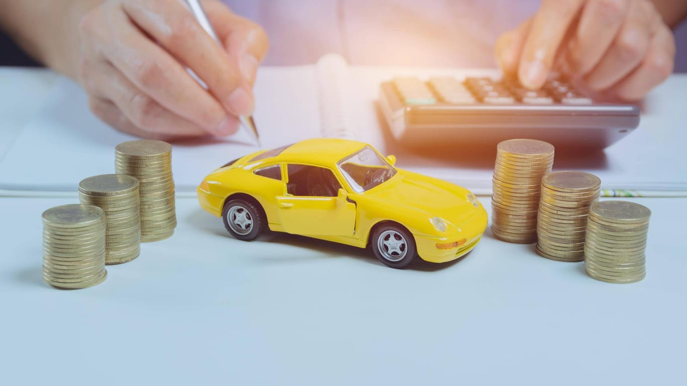 Taschenrechner und Modellauto: Wer jetzt seine Autoversicherung wechselt, könnte Geld sparen.