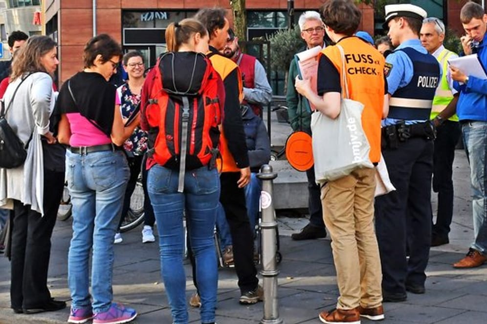 Teilnehmer eines "Fußverkehrs-Checks" in Mainz diskutieren vor dem Bahnhof Römisches Theater über die dortige Situation für Fußgänger.