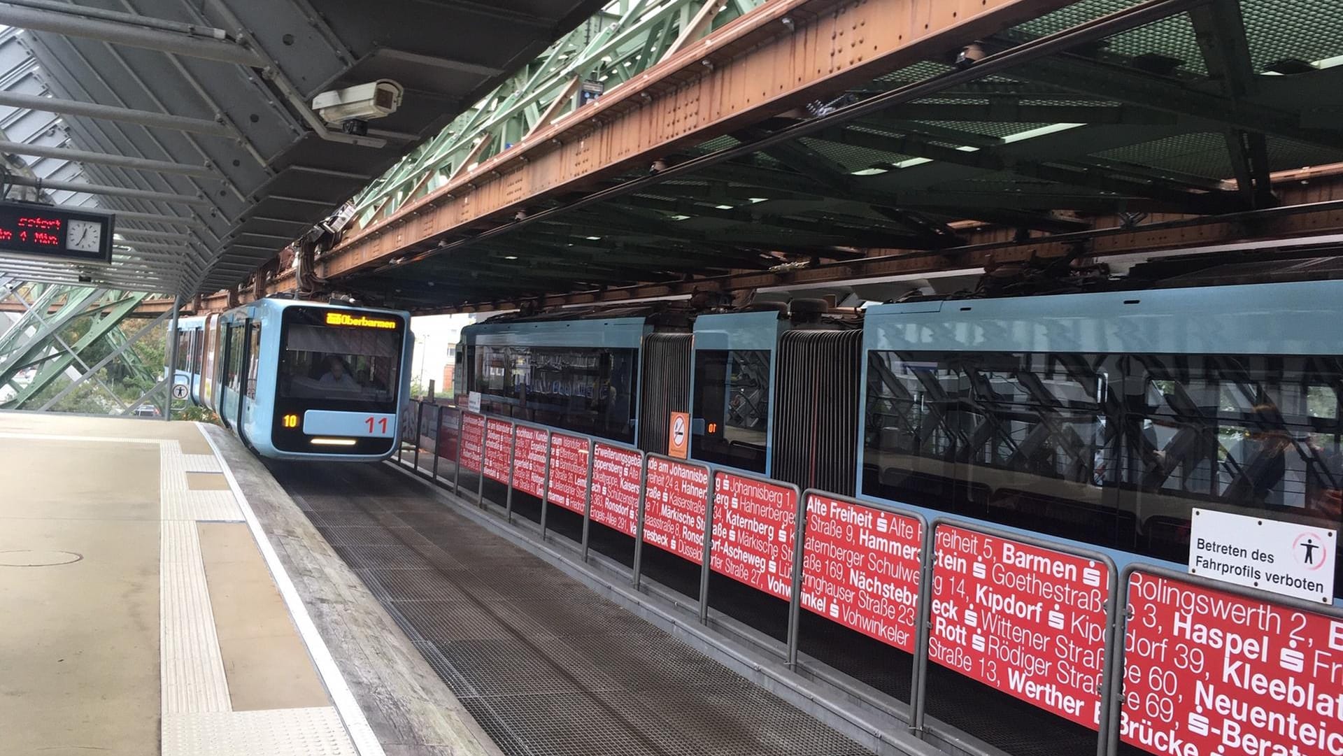 Eine Schwebebahn fährt ein: In Wuppertal kamen Gerüchte auf, wonach die neuen Wagen teilweise zu breit seien.