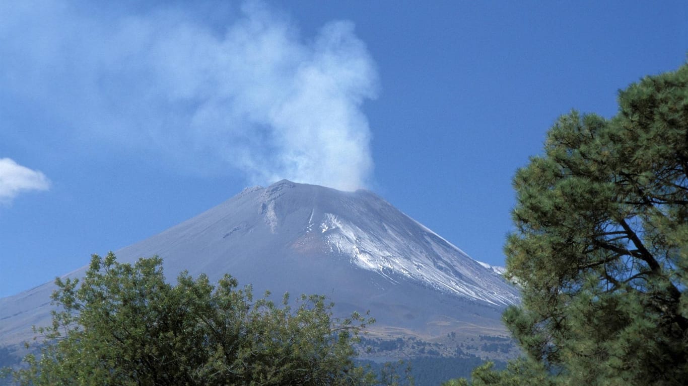 Rauchschwaden über einem Vulkan: Ein Vulkanausbruch gilt als höhere Gewalt – betroffene Urlauber können in diesem Fall von ihrer Reise zurücktreten.
