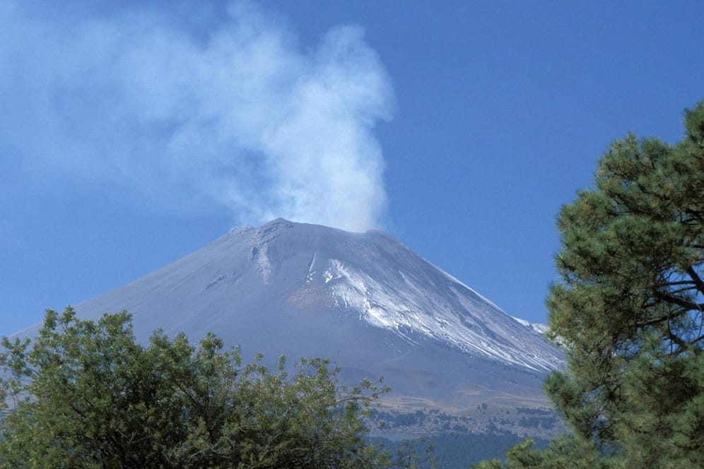 Rauchschwaden über einem Vulkan: Ein Vulkanausbruch gilt als höhere Gewalt – betroffene Urlauber können in diesem Fall von ihrer Reise zurücktreten.