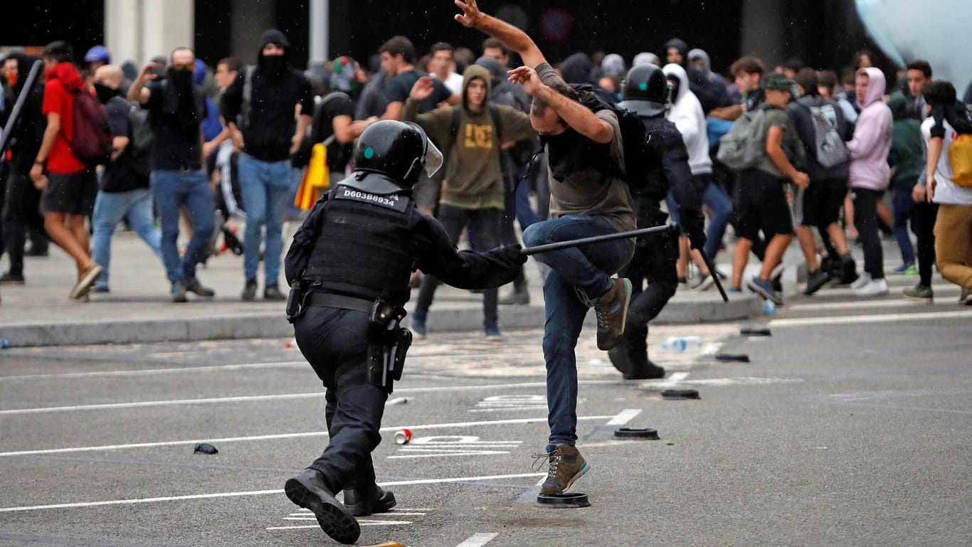 Ein Polizist schlägt einen Demonstranten mit einem Schlagstock: Am Flughafen von Barcelona sind die Proteste eskaliert.