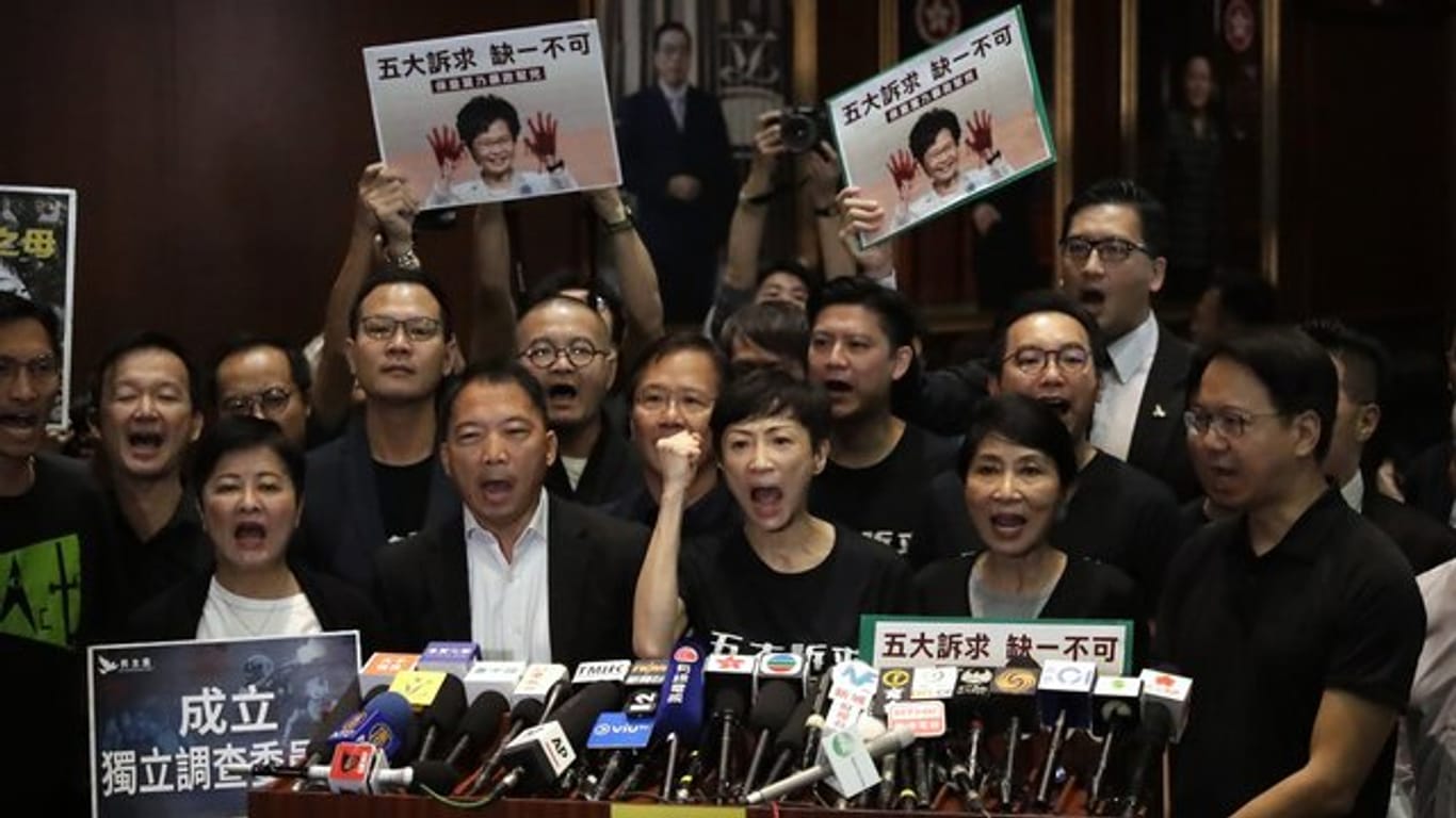 Prodemokratische Abgeordnete rufen bei einer Pressekonferenz, nachdem Regierungschefin Lam den Legislativrat verlassen hat.